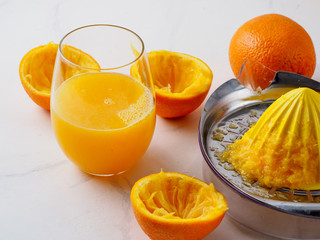 Manual juicer with cup of juice on white background.