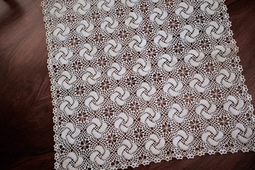 lace hand-knitted. lace tablecloth. Patterns knitted with lace crochet. Lace hand-knitted on wooden table.