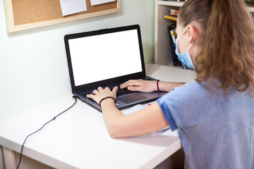Girl self isolation using laptop for her homework, distance online education