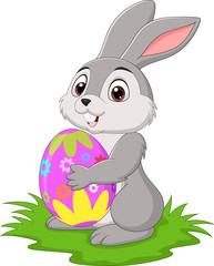 Cartoon little rabbit holding easter egg in the grass