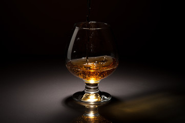 Ice cube fall and splash in beautiful glass goblet