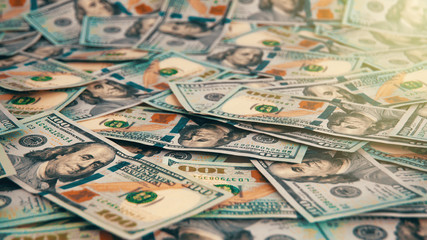 Fototapeta premium A background of scattered hundred dollar bills covering the entire space.