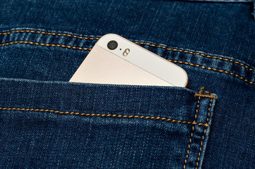 mobile phone in the back pocket of jeans trousers