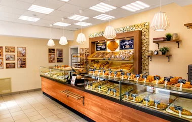 Fotobehang Baked baguettes and pies on showcase in bakery shop. Inscriptions in russian with the name baking © ArtEvent ET