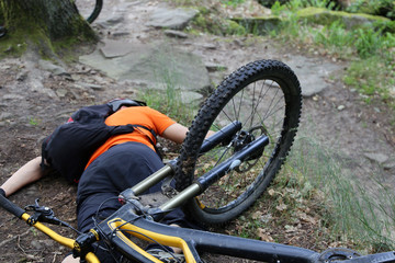Verunfallter Mountainbiker liegt verletzt auf dem Boden (Model released)