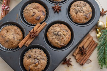 fresh chocolate muffins in muffin tin on wooden surface