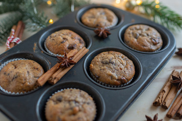 fresh chocolate muffins in muffin tin on wooden surface