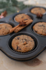 fresh chocolate muffins in muffin tin on wooden surface