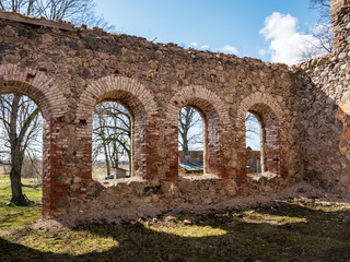 Fototapeta na wymiar landscape with beautiful abandoned church ruins, arched windows, stone walls, building without a roof