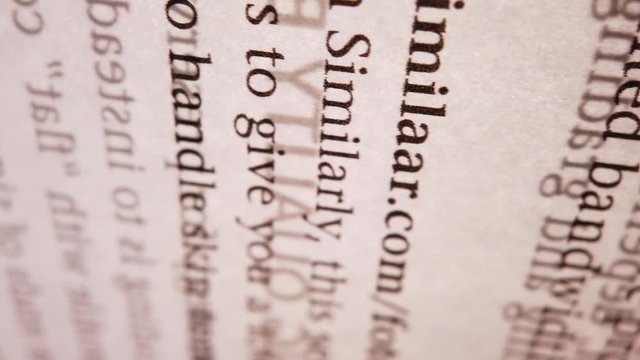 A macro panning of a book&acute;s page with light streaming through it