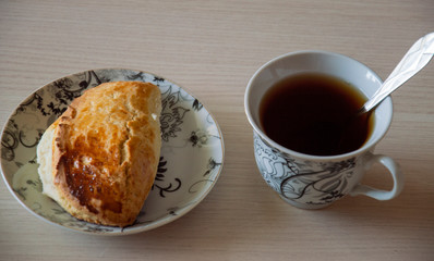 cookies on a plate and a cup of coffee with a spoon