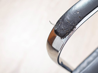 Torn and battered leather on a black office computer chair. Restoration and restoration of the...