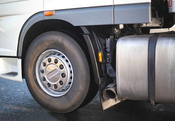 Spinning wheel of a truck and a fuel tank with an exhaust pipe. Road safety concept and adblue...