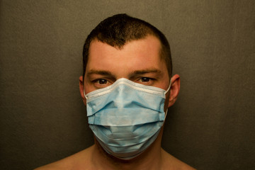 A man in a medical mask in a grey background