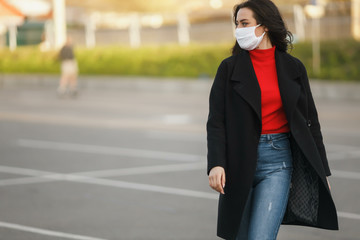 A masked girl is walking along the street. Coronavirus infection COVID-19