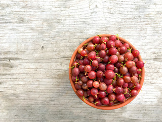 Red gooseberries. Harvest of fresh ripe red gooseberries on a wooden background.
