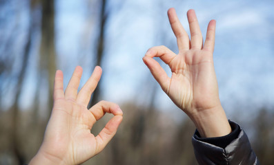 Hand sign of the symbol "good" or approx. Women's hands in the open air.