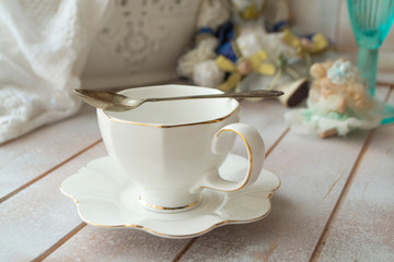 Closeup of white cup of tea on vintage wooden background.