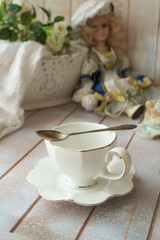 Elegant antique white tea cup on shabby table, vertical image