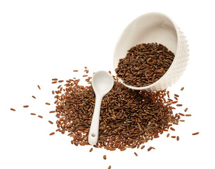 brown rice in a ceramic bowl with a white spoon on a white background