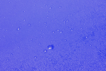 drops of water dripping close on a blue background.