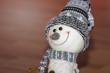 Happy snowman as Christmas decoration isolated on brown table