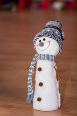Happy snowman as Christmas decoration isolated on brown table