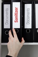 Sanitizer– finance/economics. File Folder is taken from office shelf. Male hand. Business,...