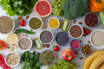 Healthy food: fruit, vegetable, seeds, superfood, cereals, nuts, leaf vegetable on gray concrete background. Set of healthy foods. The concept of a vegetarian diet.
