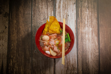 asian noodle soup with beef meatball with fresh vegetable on wood table vintage style, street food, hot and spicy noodle soup, asian food. Top view