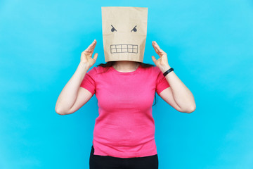 Woman standing with a cardboard on her head with angry face. Emotions concept.