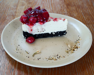 Slice of plain cheesecake with strawberry sauce on white plate.