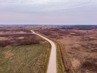 Areal view of old countryside road near agriculture fields.