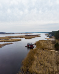 Beautiful riverside areal view of river Lielupe flowing near pine forest strees on both coast lines.