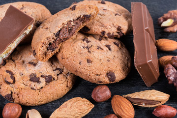 Chocolate chip cookies, chocolate pieces and various nuts close-up
