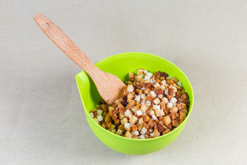 Dried bread pieces in form of cubes in plastic bowl