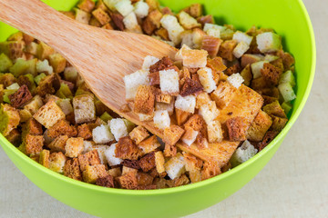 Pieces of dried bread in bowl with kitchen spatula closeup