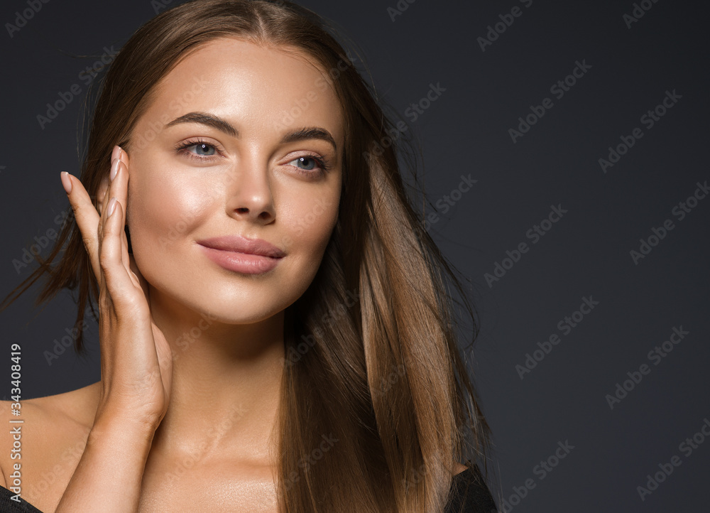 Wall mural female face beauty woman long hair fly natural make up clean healthy skin hand touching face