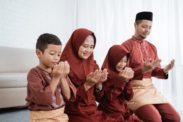 All Asian family members pray to Allah for giving gifts