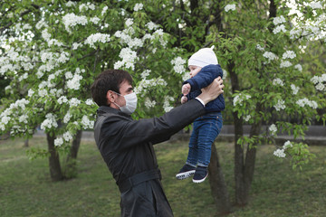 Fototapeta premium Child and man in medical protective mask on the street. Epidemic of virus covid