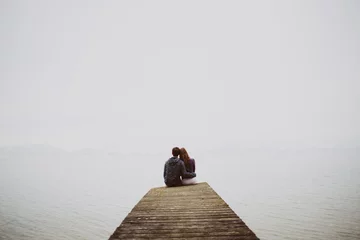 Foto op Plexiglas couple on the pier looking at a foggy lake © Lukas