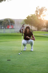 Woman golfer check line for putting golf ball on green