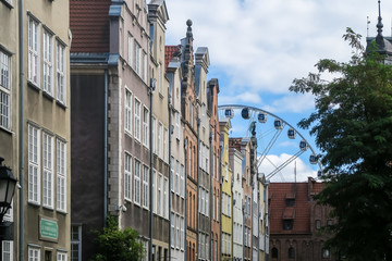 GDANSK, POLEN - 2016 SEPTEMBER 18. Old town architecture buildings and view of Ferris Wheel during sunny summer day.