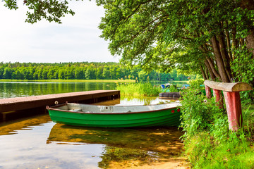 Calm relaxing nature scene. Small boat on the shore on the lake.