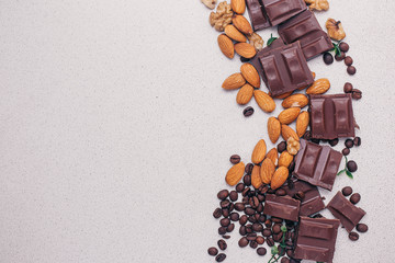 Chocolate, almonds, coffee beans on the table, top view