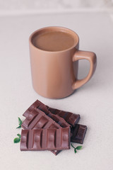 Coffee mug with milk and chocolate on the table for Breakfast