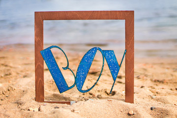 Fototapeta premium wooden inscription boy on a blue water background