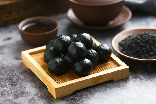 Chinese black sesame ball on bamboo plate with tea