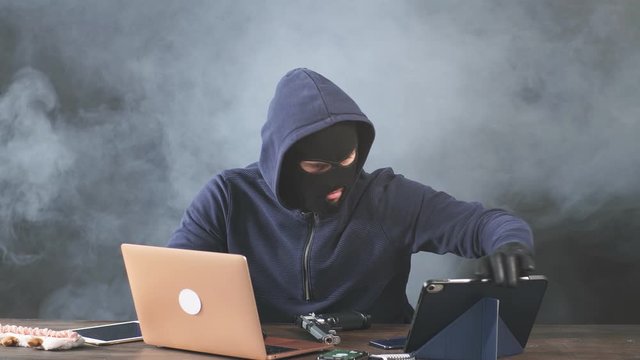 Young masked hacker disappointed by failed attempt to hack program.