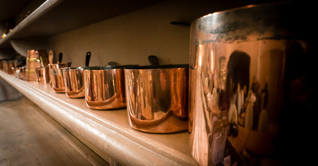 Copper pans on a kitchen shelf